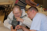 Mike Berry teaching Warren Anderson about his cell phone